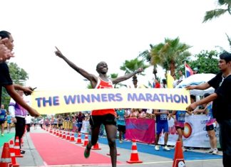 Joseph Kariuki of Kenya celebrates with arms aloft as he crosses the finish line to win the 2013 King’s Cup Pattaya Marathon, Sunday, July 21. African athletes filled the top seven positions in the men’s division and the women’s race was also won by a Kenyan athlete, but the event was more a celebration of spirit and fortitude as runners of all ages and nationalities took to Pattaya’s streets to face their own personal sporting challenges. (PM Photo/Phasakorn Channgam)