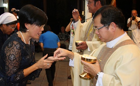 Father Michael Picharn presents communion to Toy, Father Ray’s ‘right hand woman’.