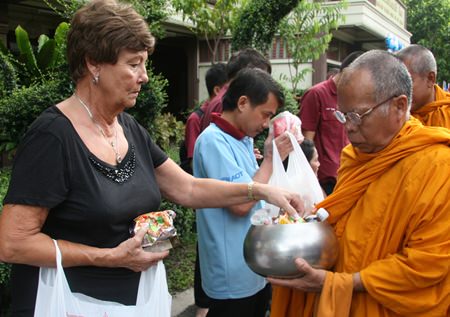 Sharron Purtell offers food to the monks.
