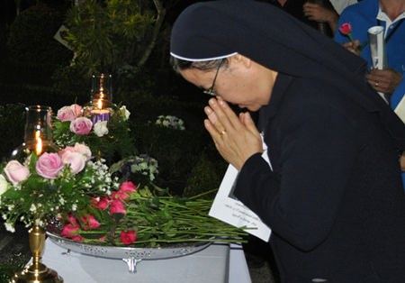 Sister Supatra pays her respects to Father Ray.