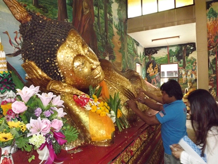 Many people paste gold leaf on Buddha statues, asking for prosperity for their family and themselves.