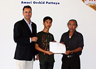 Richard Margo (left), Resident Manager of the Amari Orchid Pattaya, and Chanarong Kosolwat (right), free artists, present a certificate to Nattawut Chumanowat (center) from Silapakorn University.