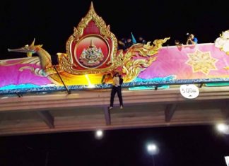 Police and Sawang Boriboon rescuers use rope to pull Sirisak Chanduaykij to safety on the decorative bridge near Pattaya School No. 7.
