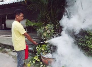 Athit Meemakzup puts out the fire with his handheld extinguisher.