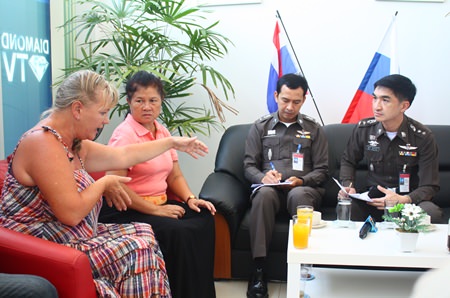 Pol. Col. Suwan Chiewnawinthawat (right) and Pol. Lt. Col. Anek Srathongyuu listen to complaints from Russians at the Russian Convenience Center in Jomtien.