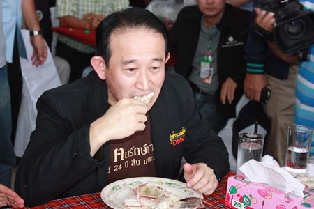 Pornthep Siriwanarangsan, director-general of the Disease Control Department, indulges in the local crab whilst trying to convince others that Koh Samet seafood is safe to eat.