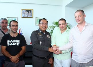 Capt. Samruay Saman (center), deputy suppression inspector for Chonburi Immigration, shakes hands with Illia Miasnikov (2nd right), Security Advisor at the Russian Convenience Center, as other Russians look on.