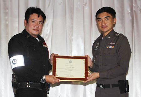 Pattaya Superintendent Col. Suwan Cheaonawinthawat presents a citation to Sen. Sgt. Maj. Jinna Son-unn, a traffic officer cited for ethical and moral behavior.