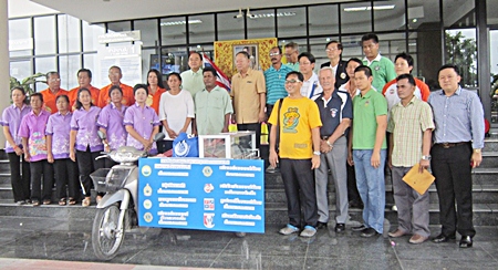 The mayor and staff of city hall pose around the new motorbike and all its accessories, and thank PSC.