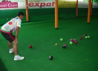 Lawn bowls at Coco Resort Go from Bangkok Mens studies an end before bowling.