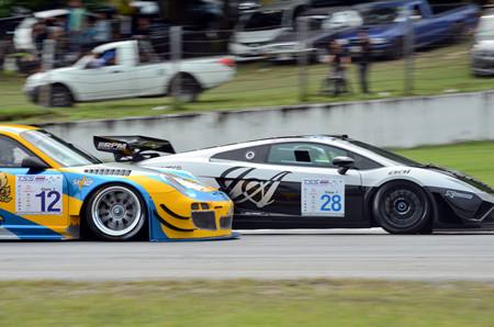 Chonsawat’s Lamborghini Gallardo (right) holds off the challenge of Piti Phiromphakdee’s Porsche 997 GT3R.