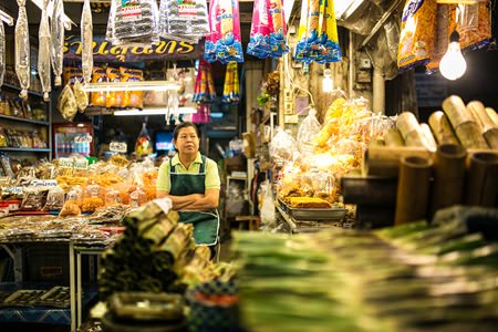 A vendor and her array of local snacks at Nong Mon market.