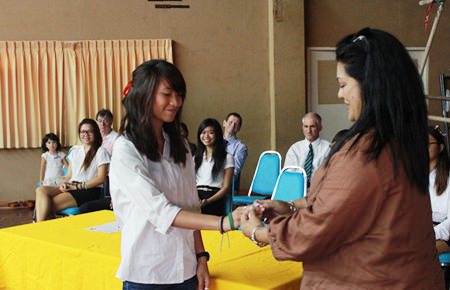 Humanities Prefect Trisha gets a special white GIS wristband from her mother.