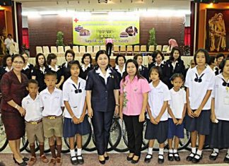 Red Cross Vice-President Sasithorn Preechawit leads members of the Chonburi Red Cross in handing out a million baht in scholarships and providing free bicycles.