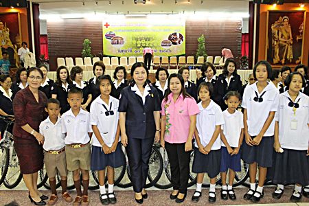 Red Cross Vice-President Sasithorn Preechawit leads members of the Chonburi Red Cross in handing out a million baht in scholarships and providing free bicycles.