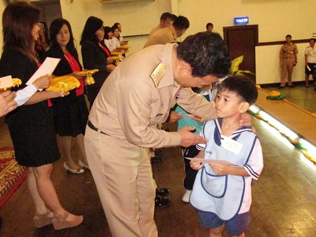 Vice Adm. Chainarong Charoenrak hands out one of the 220 scholarships to a deserving student.