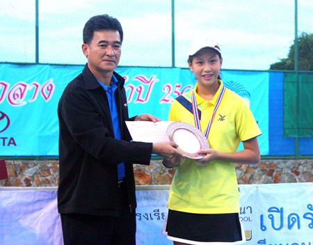 Jirasak Saksansin (left), Senior Manager of TOT Pattaya, presents an award to Manita Bussarakhomvisit, the winner of the female single U 18 title.