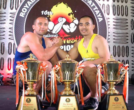 Arturs Dorohous of Latvia (left) and Thailand’s Suthiwas Kohsamut pose with the champions’ trophies at the conclusion of the 10th Pattaya International Arm Wrestling Championship at the Royal Garden Plaza, Saturday, Sept. 14.