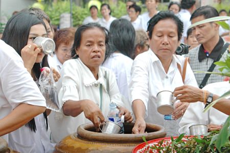 People flock to the jars of holy water to drink it and spray some on themselves to detoxify their outer and inner bodies before the vegetarian festival.