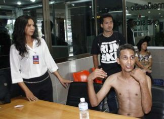 Bunjan Honphukiew (seated, shirtless) tries to explain to police what might have happened to him.
