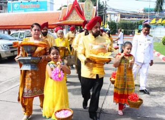 Mohinder Singh (2nd right) and Savinder Kaur Gulati (left) and their family bring the Thod Kathin robes from home to Wat Chaimongkol.