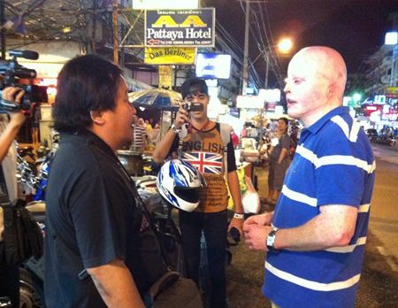 Ronan Bradley (right) talks with motorcycle taxi drivers at the site of the 2004 accident.