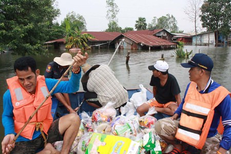 Relief workers paddle to inundated homes, bringing what relief supplies they can.