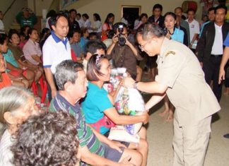 Deputy Interior Minister Visarn Techateerawat hands out bags of flood relief supplies to residents of Panthong.