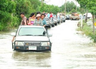 The governor and his entourage make their way into flooded Phanat Nikhom to hand out relief supplies.