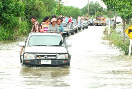 The governor and his entourage make their way into flooded Phanat Nikhom to hand out relief supplies.