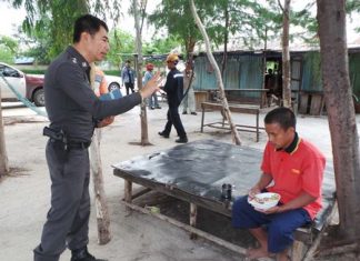 Police try to communicate with the Vietnamese fisherman after giving him some rice to eat.