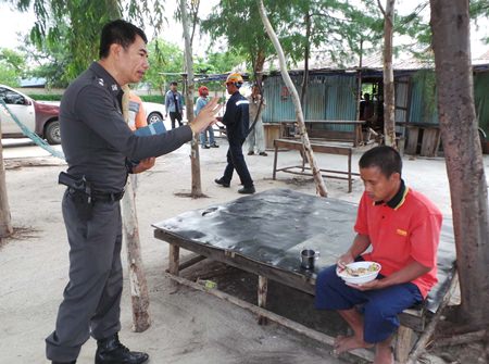 Police try to communicate with the Vietnamese fisherman after giving him some rice to eat.