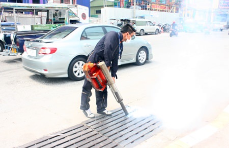 Officials from Pattaya’s Public Health Department spray mosquito pesticide into the drains on Pattaya 2nd Road.