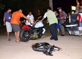 Police and rescue workers remove what is left of the motorcycle.