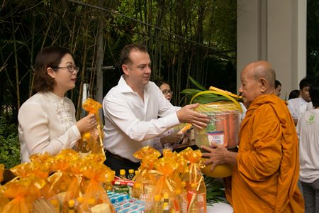 Garth Solly, GM of Holiday Inn Pattaya presents alms to revered monk.