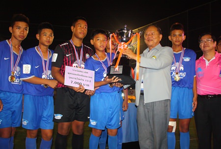 Nongpure municipal president Mai Chaiyanit (center-right) presents the champions trophy to the Chonburi FC under-13 team.