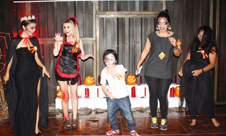Contestants in the Zulu Bar’s scary costume contest, won by the youngster in the middle, perform their scariest dance moves for the judges.