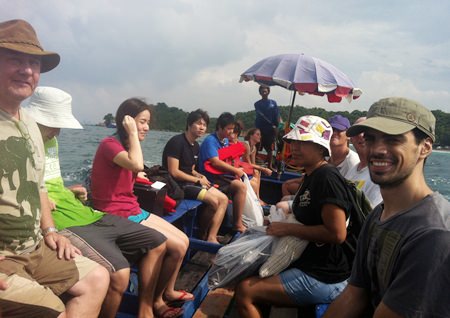Volunteers from Rotary, Mahidol University and students from Argentina return to the boat after cleaning.