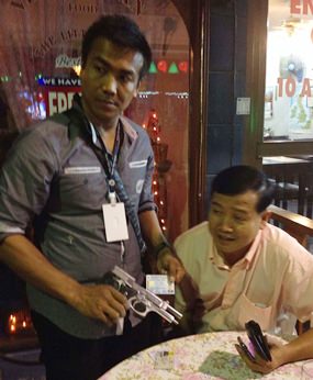Police take the 9mm handgun and ID from Yuthana Khanthong during his arrest.