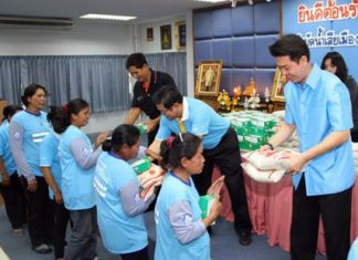 (From left) Chalerm Kaetjae, deputy head of the Chonburi PAO, along with Deputy Mayor Verawat Khakhay and Chonburi MP Poramet Ngampichet, present rice and medical kits as bonuses to sanitation workers.