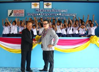 Children show off the rock ‘n’ roll symbol to thank Jorge Carlos Smith (right), General Manager of Hard Rock Hotel Pattaya & Hard Rock Cafe Pattaya, shown here shaking hands with Viroj Ampornvichai (left), director of Huay Yai School, during the presentation of the new canteen.