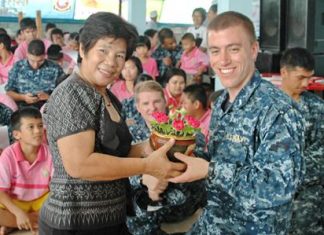 Teacher Boonchu Muangmaitong (left) presents a thank you gift to a representative of the USS Mustin Crew.