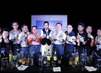 Sansiri executive Uthai Uthaisangsuk (5th right) and Niks Anuman-Rajadhon (center) pose for a photo with cocktail mixing members of the media at the exclusive party held at Baan Plai Haad on Nov. 22.