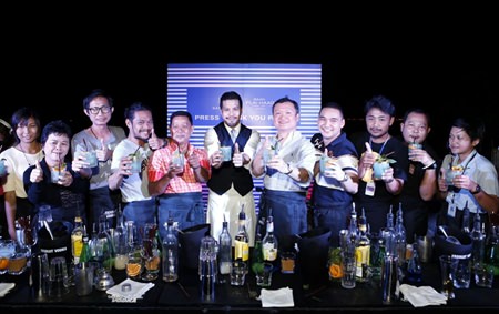 Sansiri executive Uthai Uthaisangsuk (5th right) and Niks Anuman-Rajadhon (center) pose for a photo with cocktail mixing members of the media at the exclusive party held at Baan Plai Haad on Nov. 22.