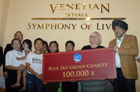 Surjeet Sing Chawala (right) presents a cheque for 100,000 THB to Tracy Cosgrove (2nd right) and the children of the Sanuk Day Care Center.