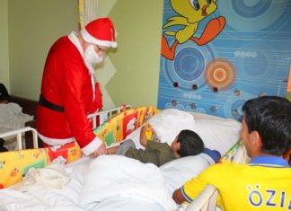 Santa Claus visits a young patient at Bangkok Hospital Pattaya to give him some gifts and lift his spirits.