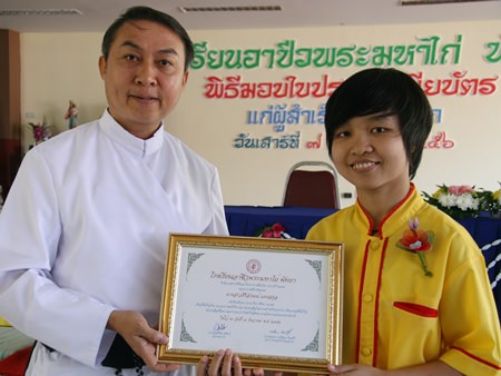 Sirirak Daengsakun receives an award for outstanding work from Father Peter, President of the Father Ray Foundation.