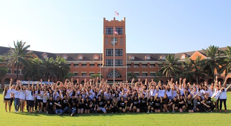 Students and organisers gather for a group photo in front of the school.