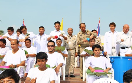 Chonburi Gov. Khomsan Ekachai (center left) and Mayor Itthiphol Kunplome (center right) cut the first locks of hair for novices entering the monkhood in honor of His Majesty the King.