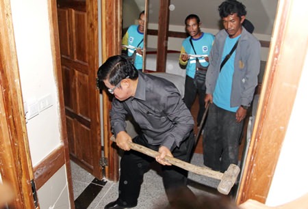 Deputy Mayor Verawat Khakhay leads the demolition team in taking apart the illegal structure.